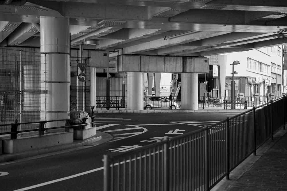 grayscale photography of railings and road
