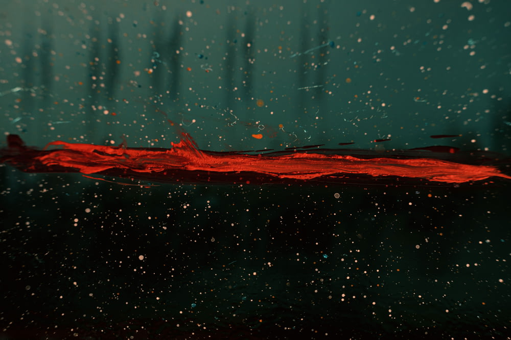 a close up of a red substance on a black surface