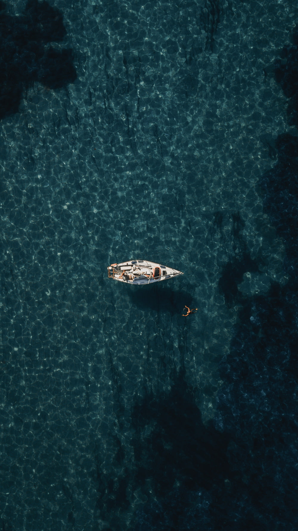 水域に浮かぶ白いボートの鳥瞰図