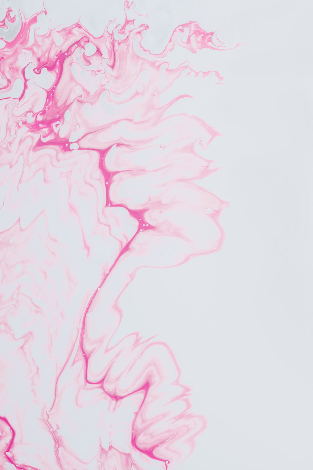 a white background with pink ink swirling around it