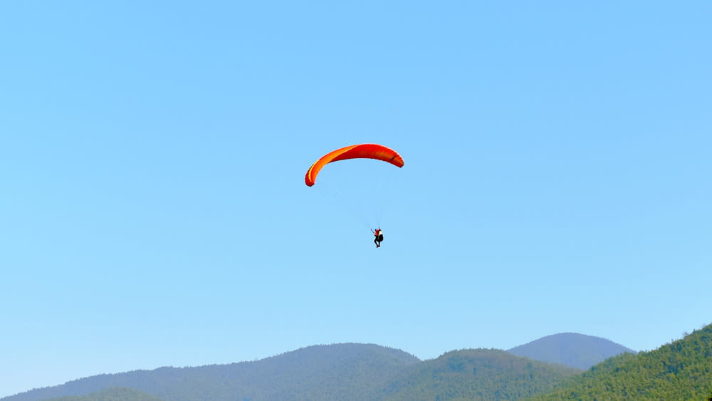 person in a parachute during clear blue sky