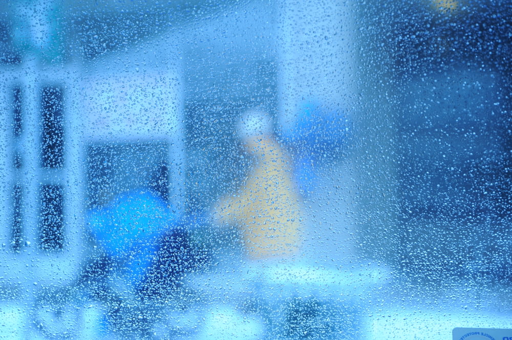 窓から雨の中を歩く人のぼやけた画像