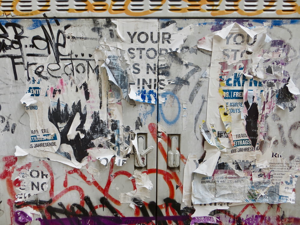Eine Wand, die mit vielen verschiedenen Arten von Graffiti bedeckt ist