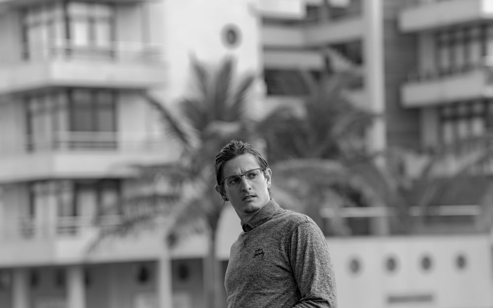 grayscale photo of man wearing long-sleeved top