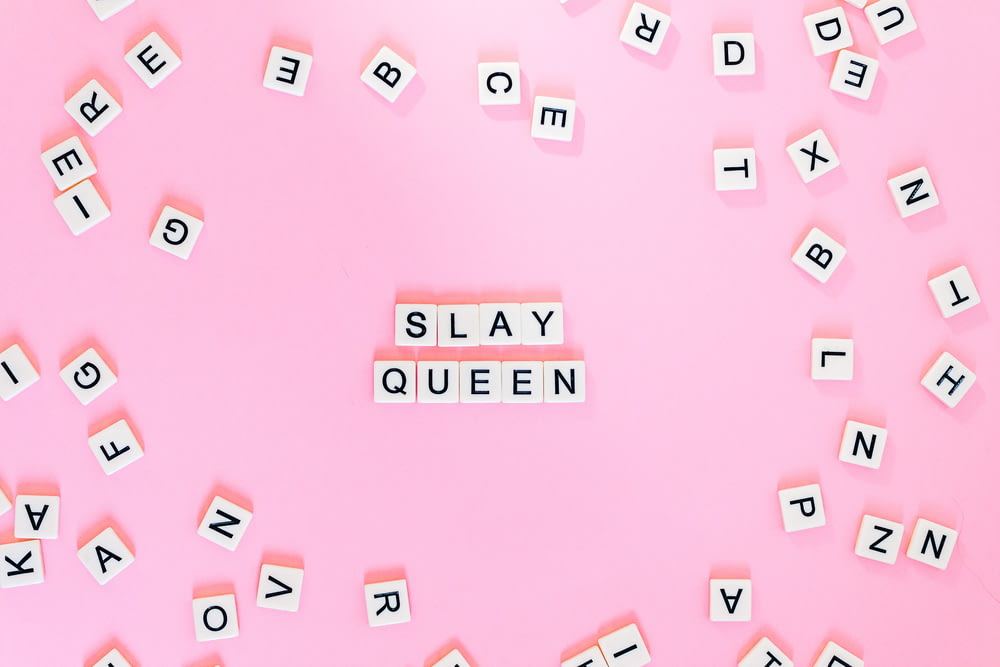 Scrabble pieces on pink surface