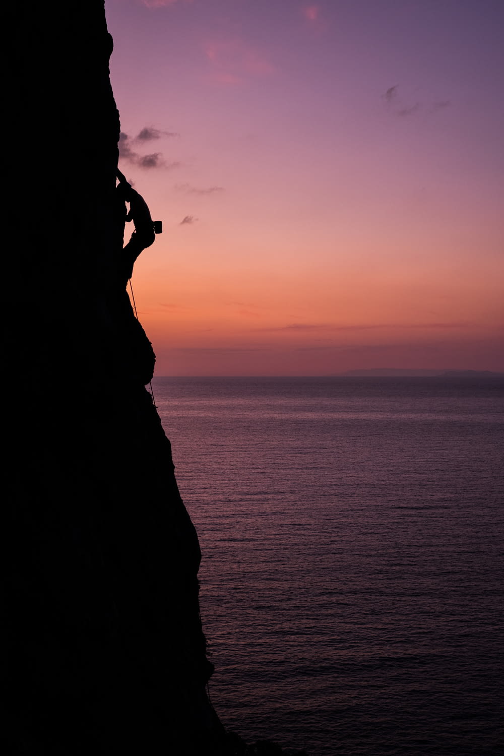 a person climbing up the side of a cliff