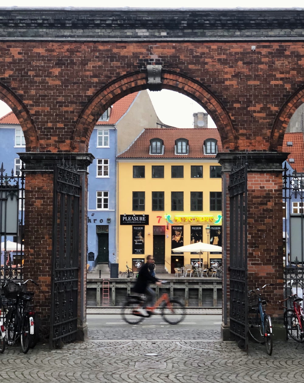 a man riding a bike through a brick archway