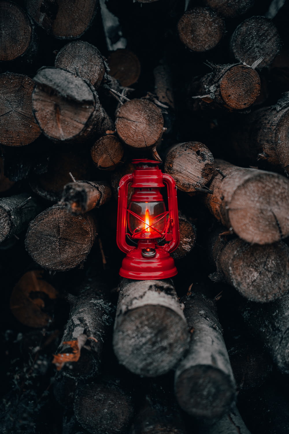 red lantern lamp on piled fire wood