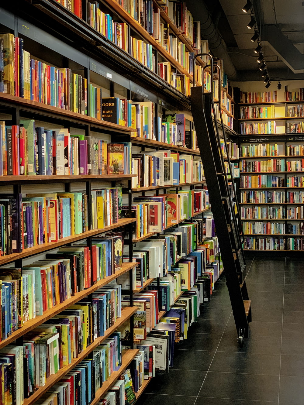 a long row of books on shelves in a library