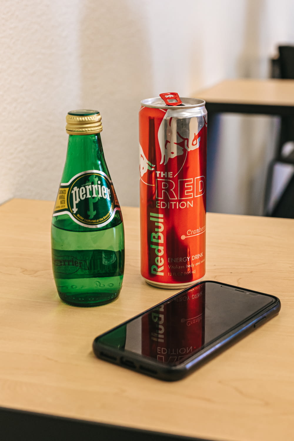 two soda cans beside smartphone