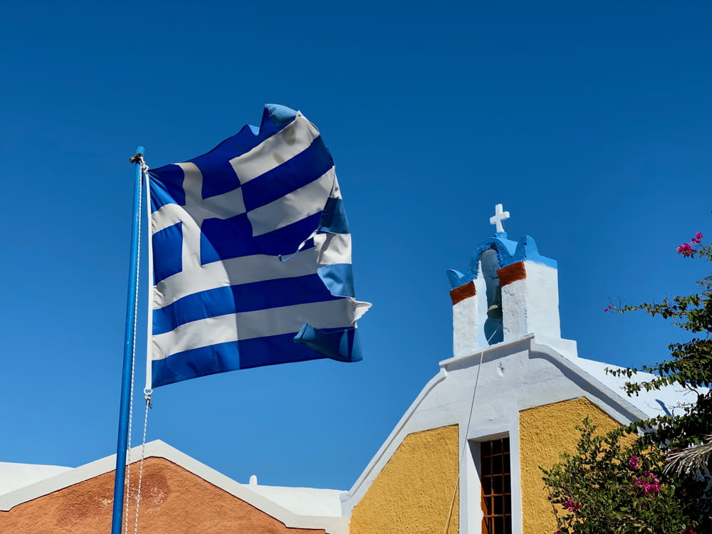 Bandera blanca y azul cerca de la iglesia