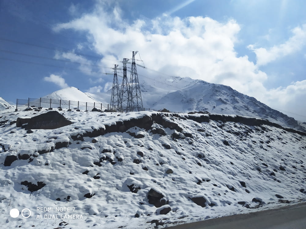 three utility tower above the hill with snow