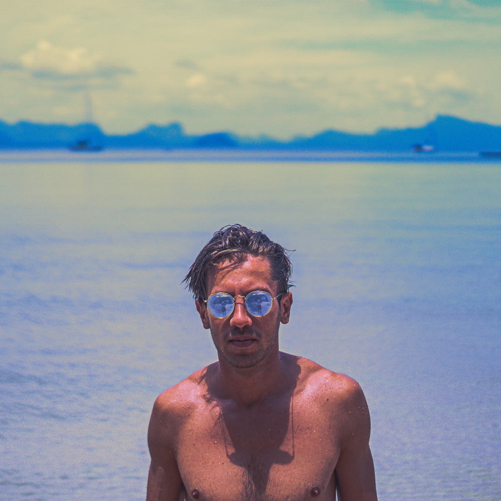 man in gold-colored sunglasses behind sea