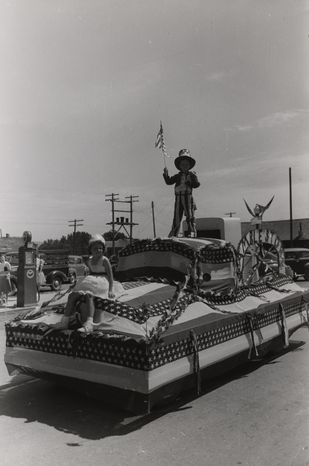 grayscale photography of children riding a USA-themed float