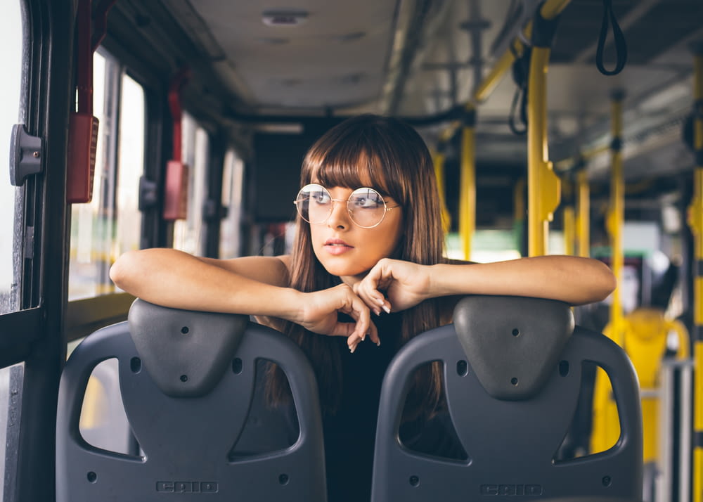 selective focus photography of woman wearing eyeglases riding bus
