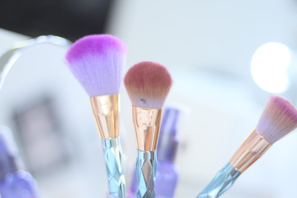 three blue makeup brushes