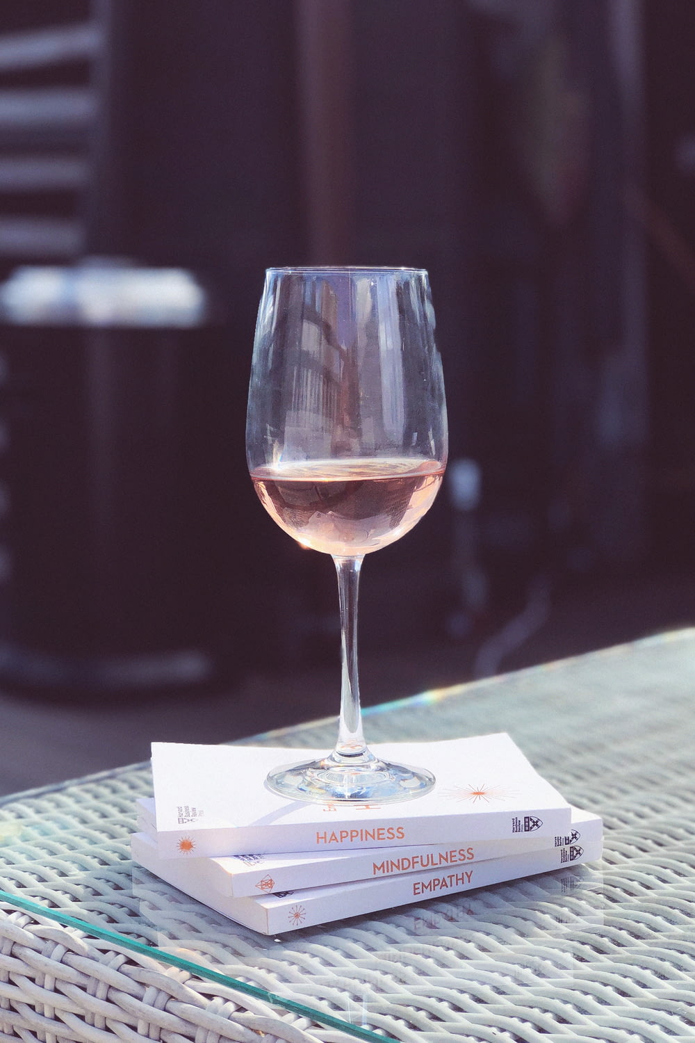 selective focus photography of filled clear wine glass on books