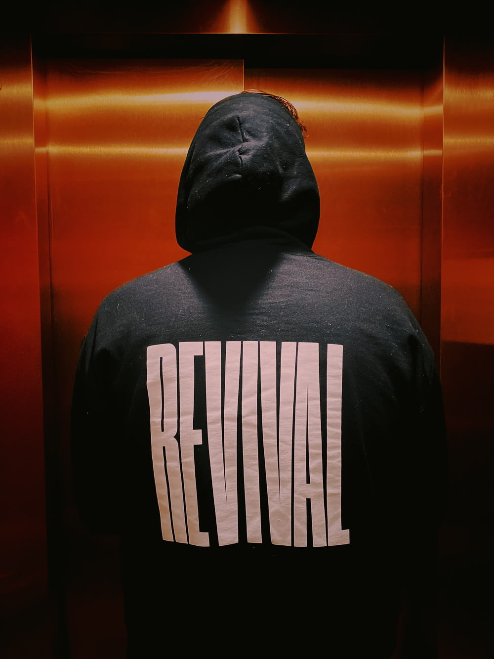 person wearing black Revival hoodie jacket