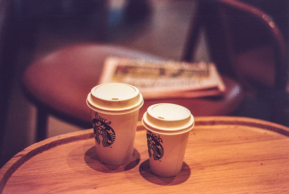 zwei weiße Starbucks-Einwegbecher