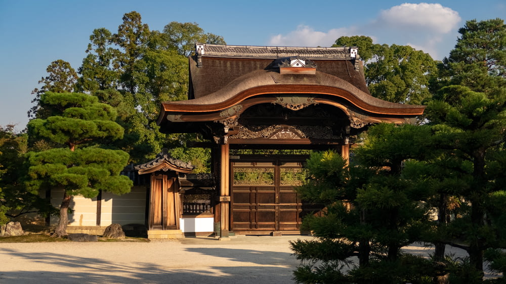 brown wooden pagoda gate surrounded by green trees
