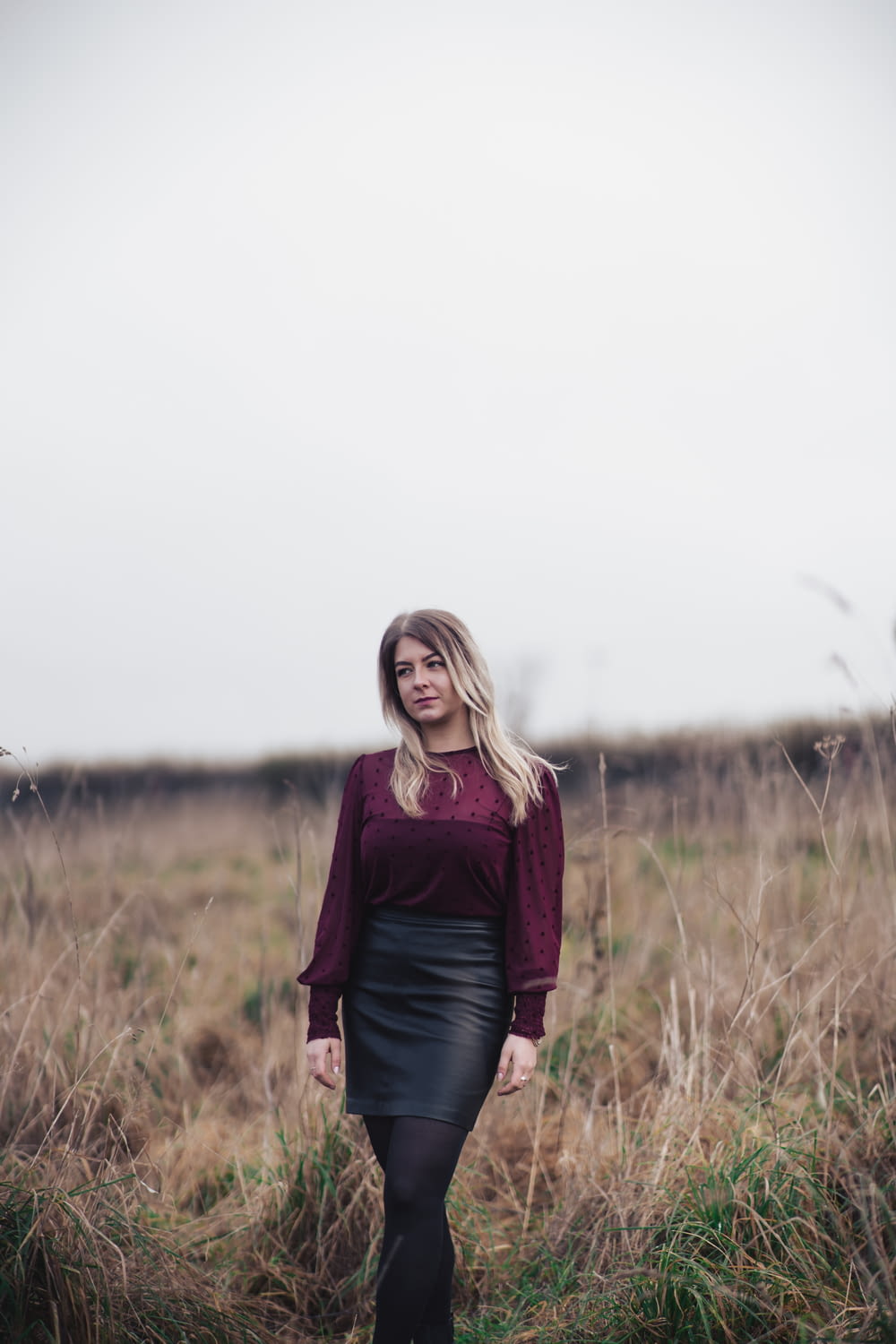 woman in red long-sleeved top and black skirt standing outdoors