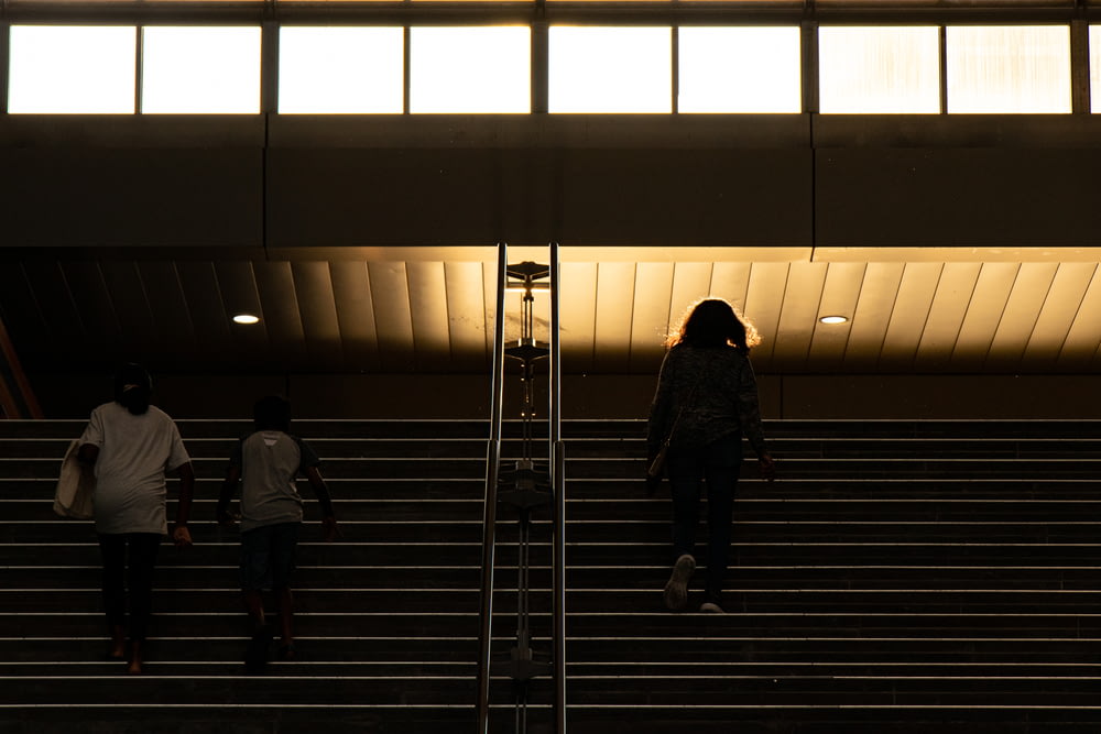 three people walking on stairs going up stairs