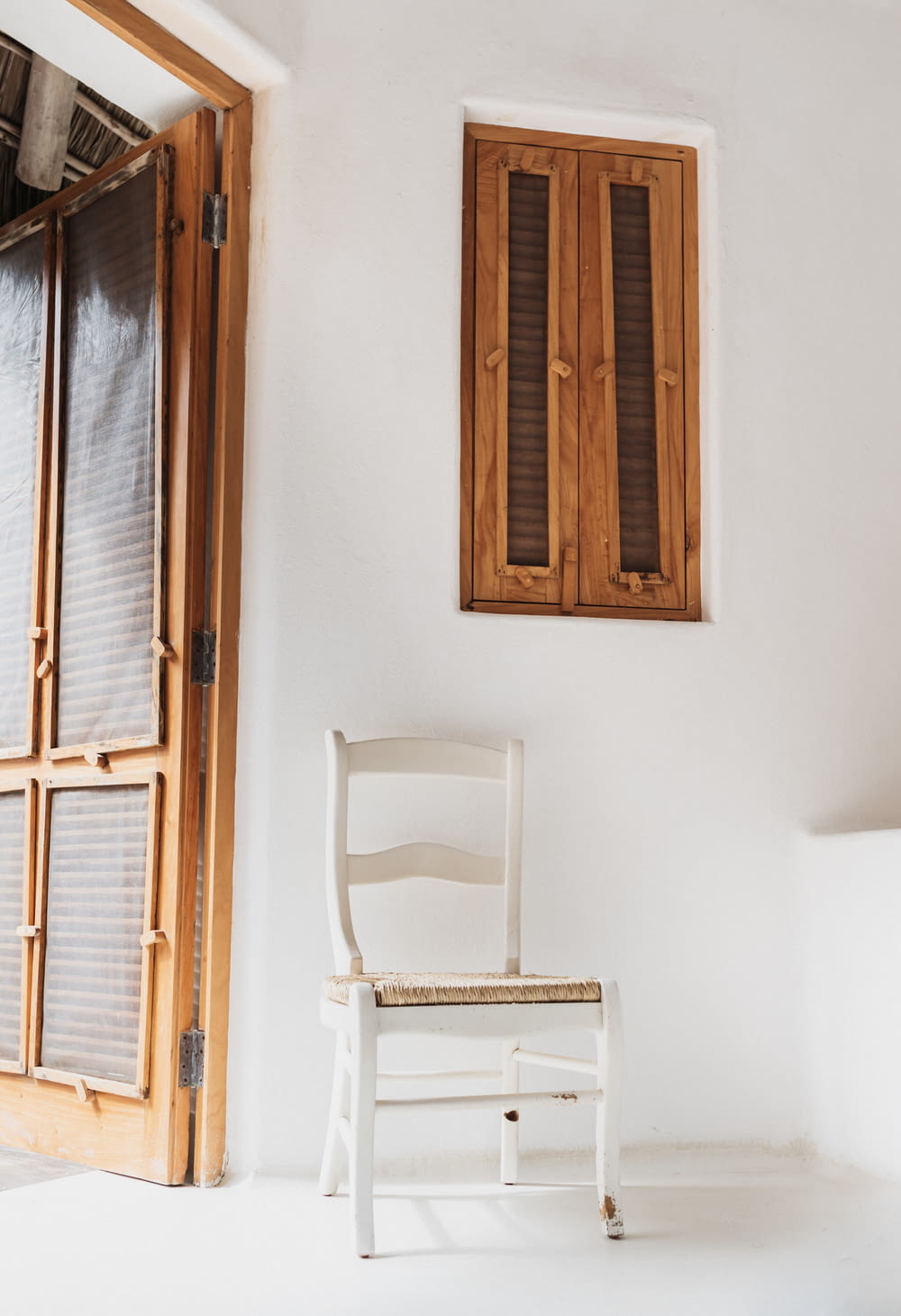 white wooden chair beside wall