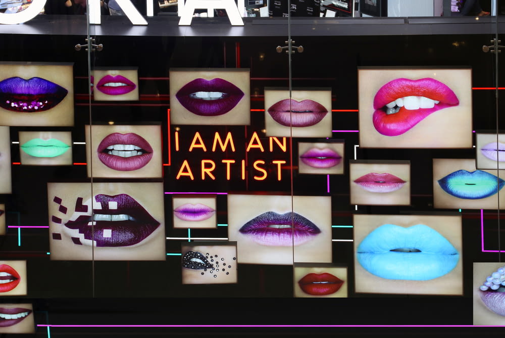 assorted-color lipsticks on glass wall