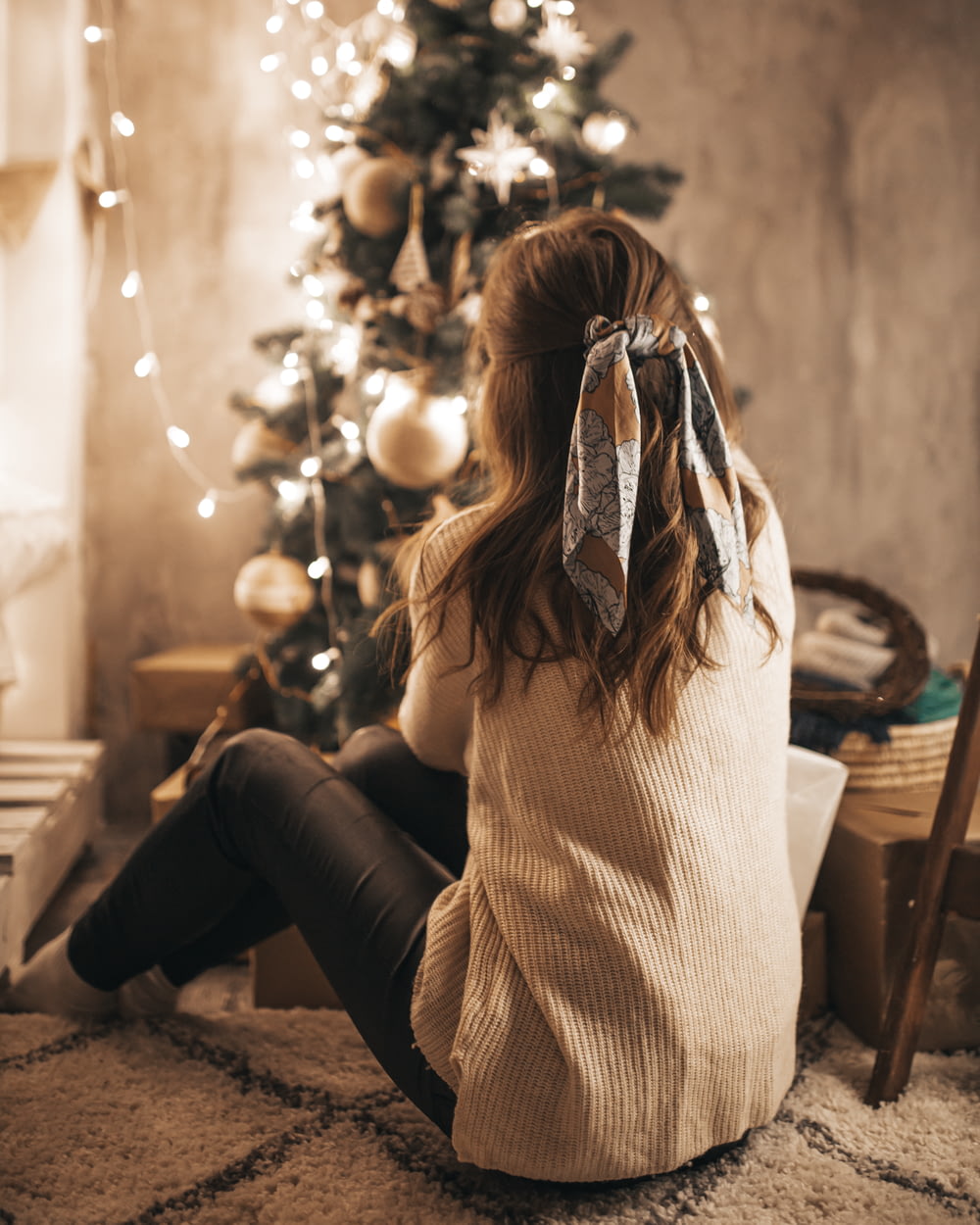 woman sitting near Christmas tree