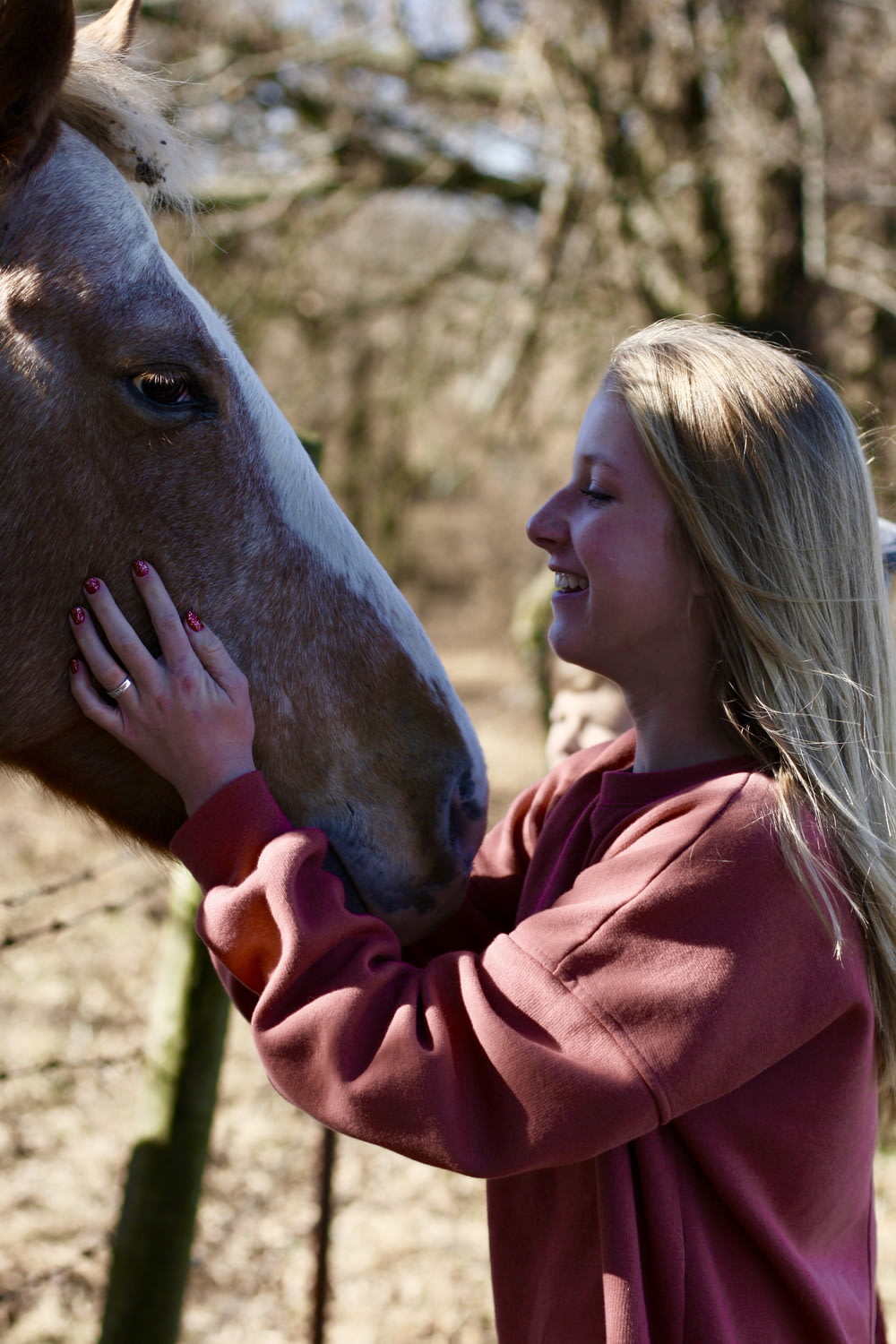 woman smiling and facing horse