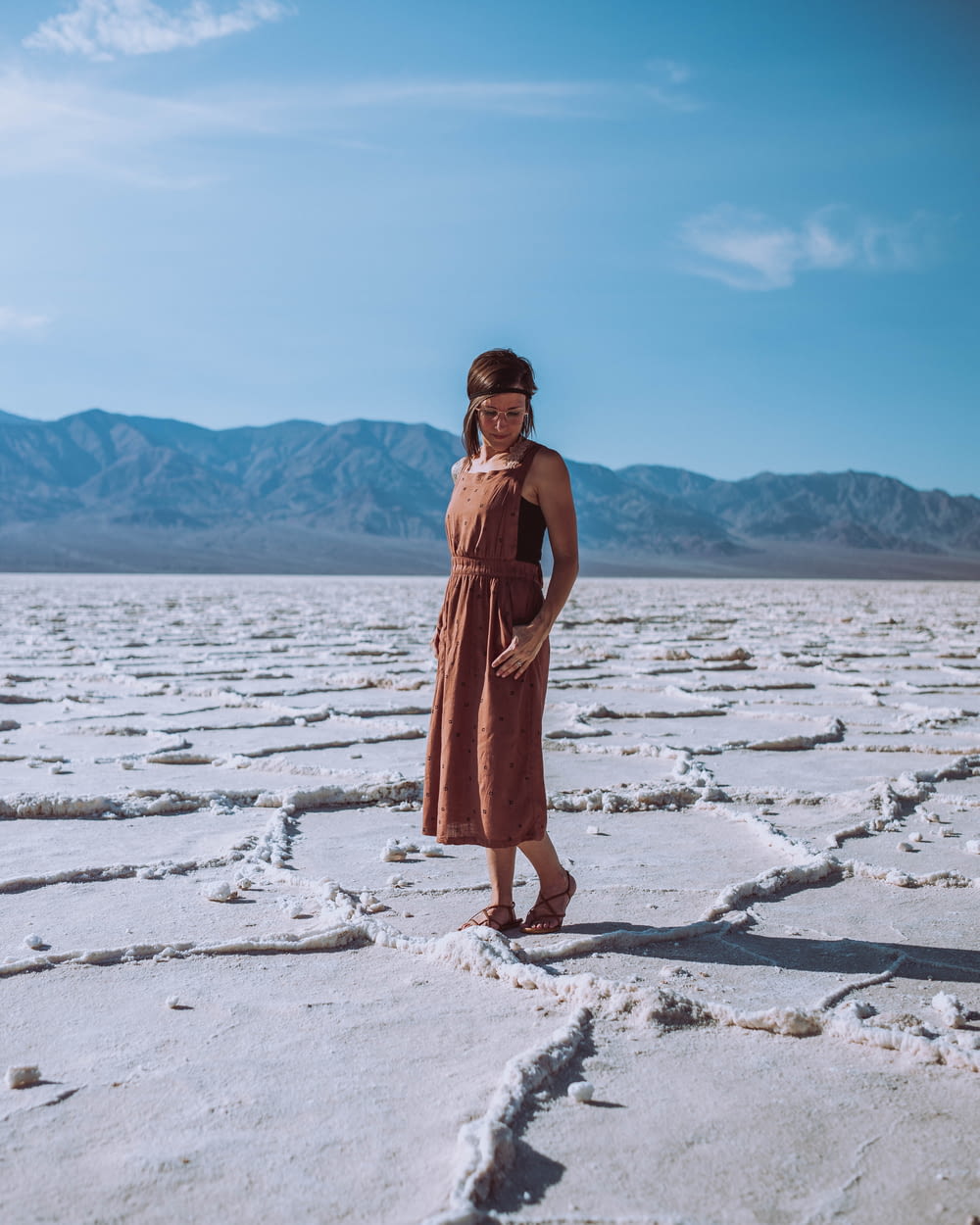 woman wearing brown dress standing on icy surface