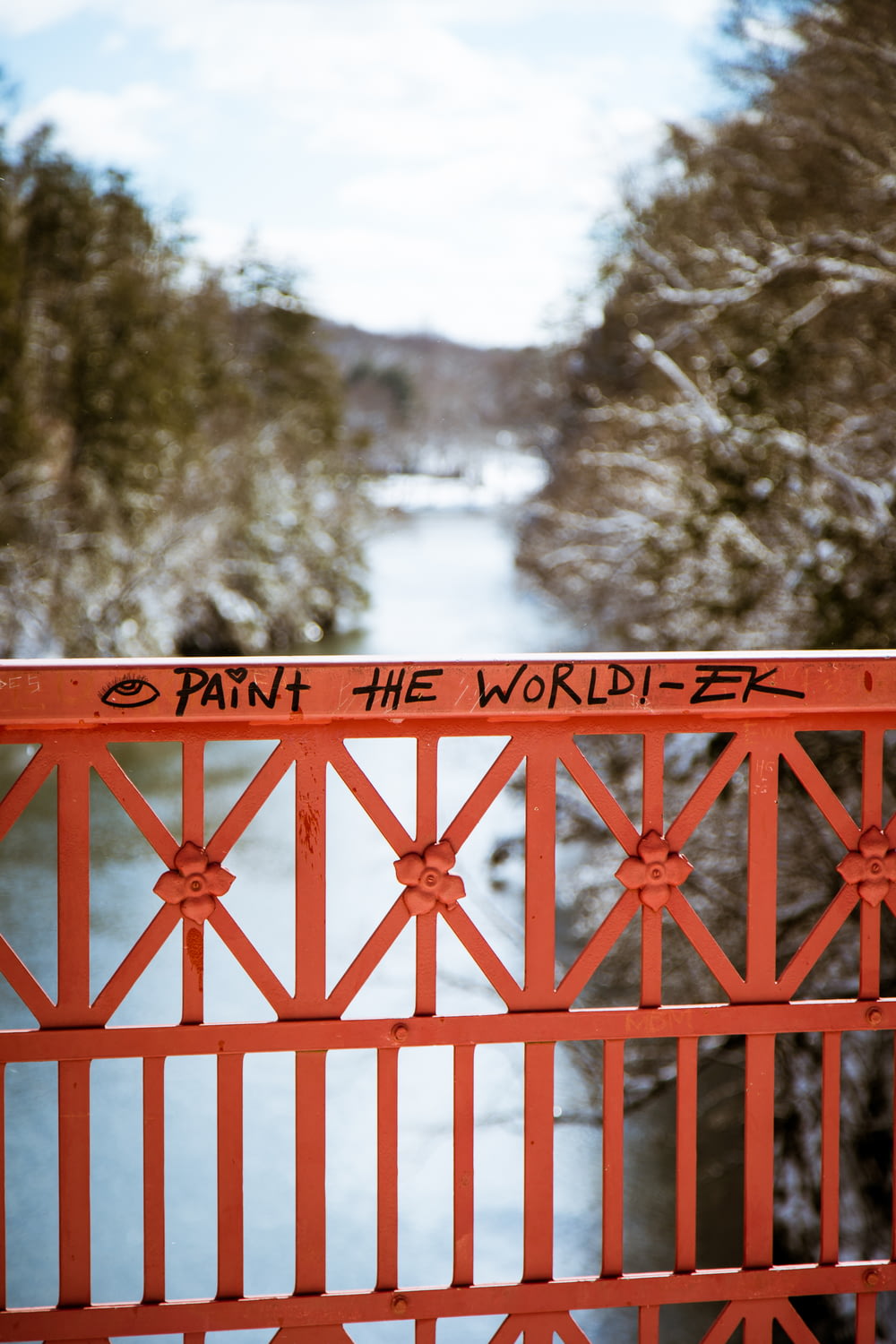 Peignez le monde écrit sur un rail de pont en métal rouge