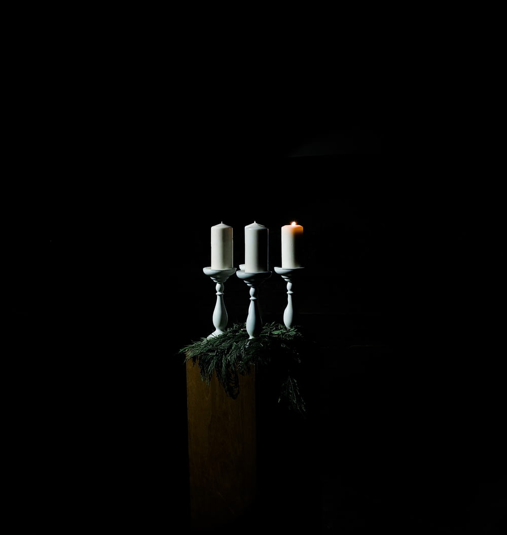 low-light photo of white pillar candles