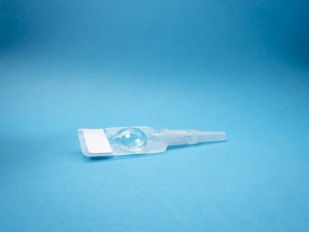 white plastic tube on blue surface