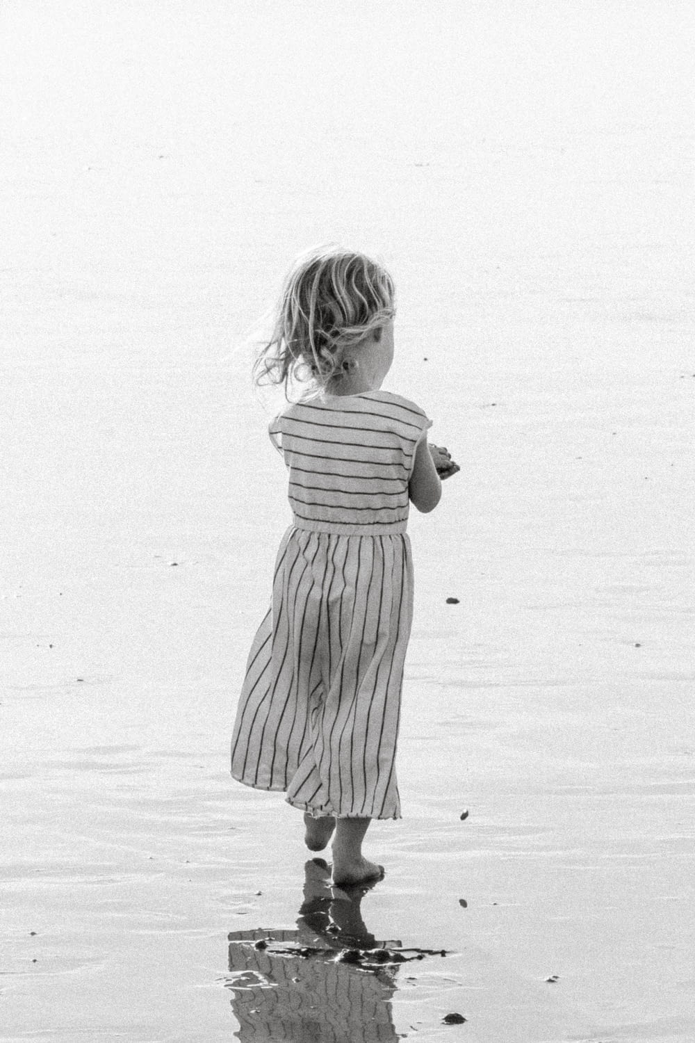 a little girl that is standing in the water