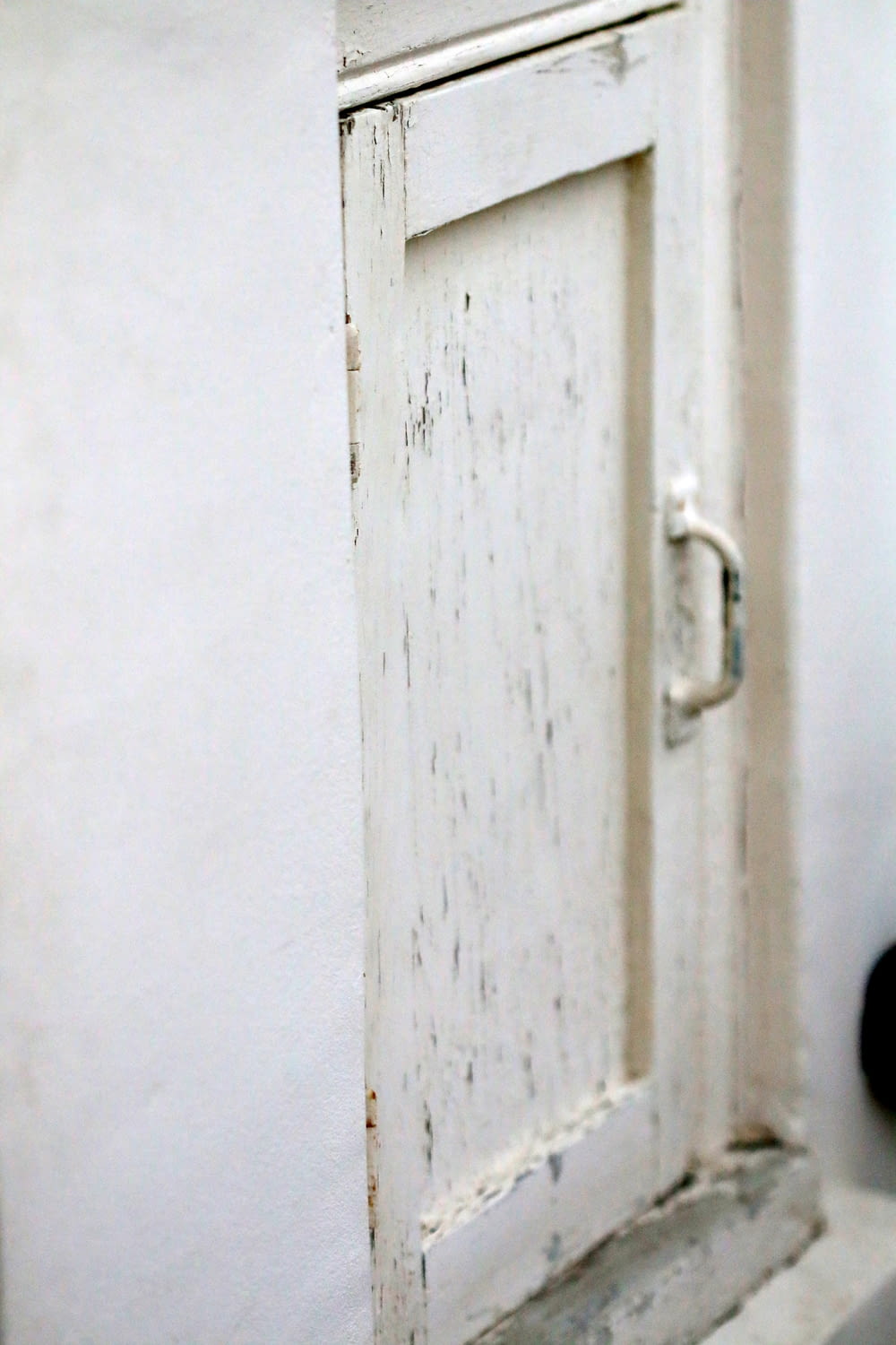 a white door with a handle on a white wall