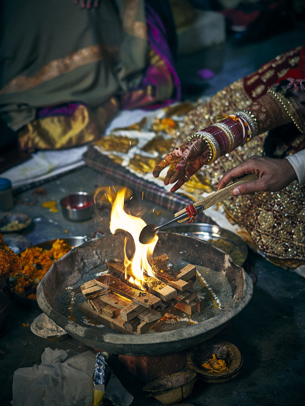 a woman is lighting a fire in a bowl