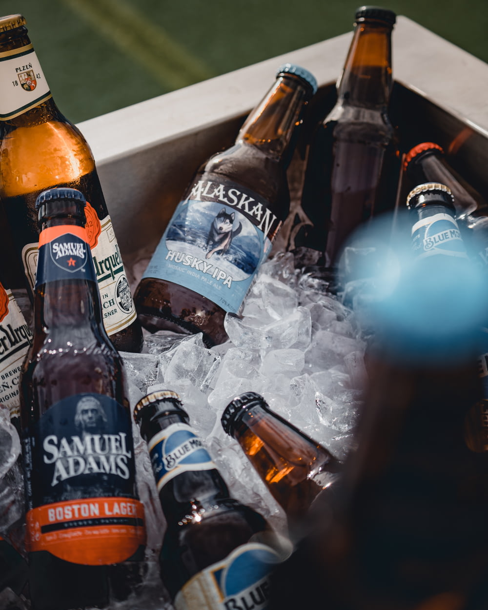 Samuel Adams beer bottles on a chest cooler with ice cubes