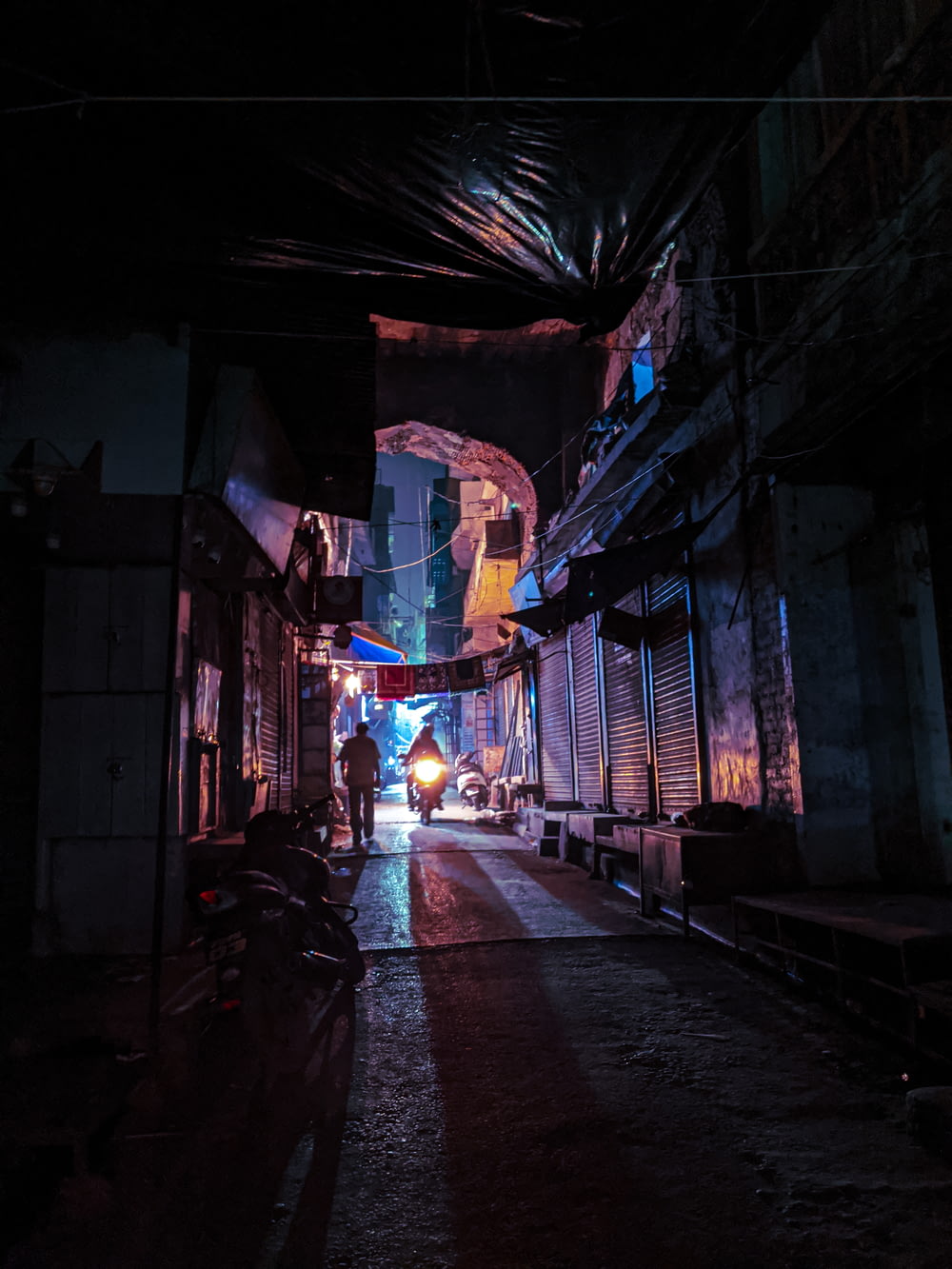 a dark alley with a person walking down it