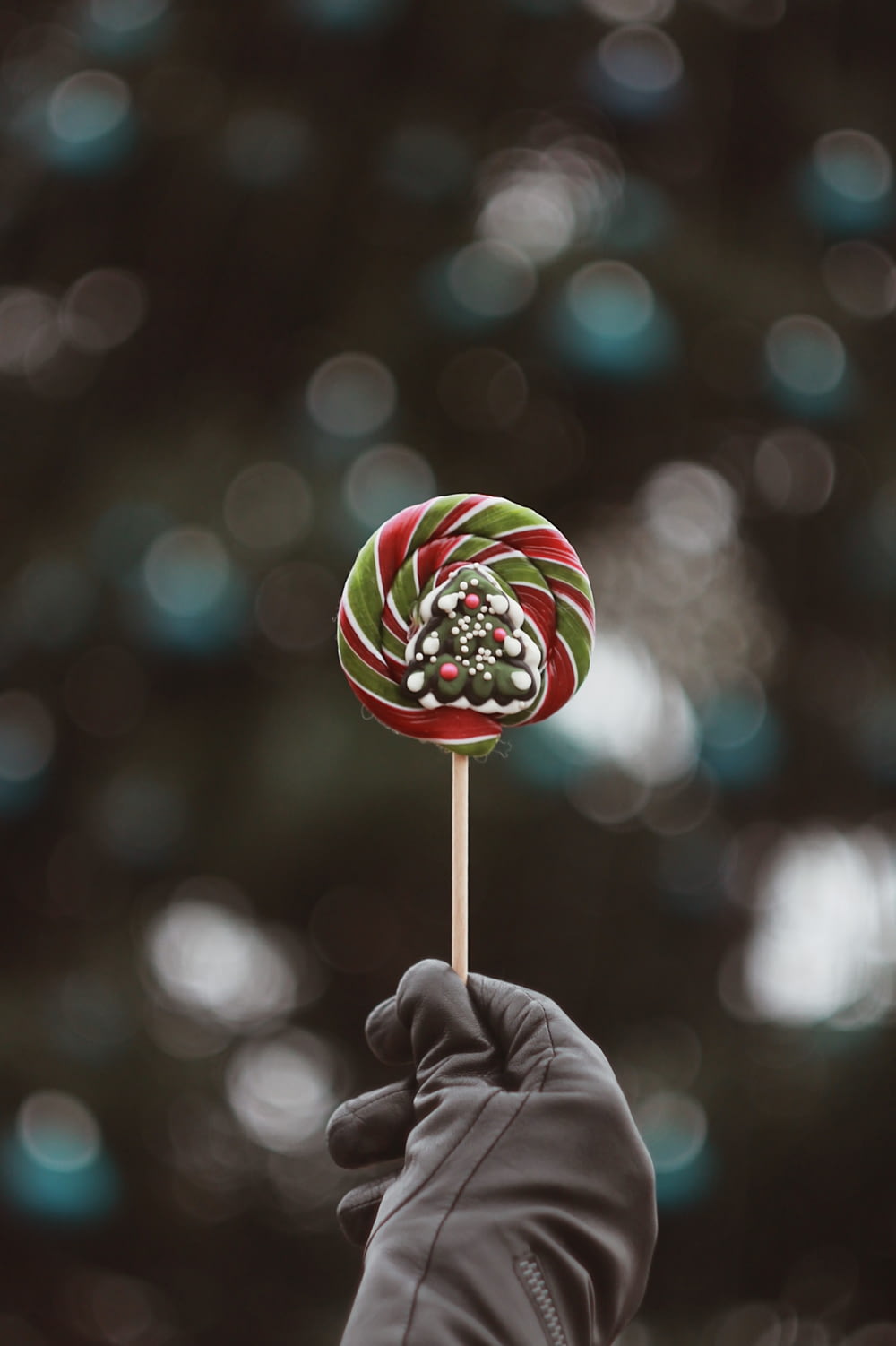 person holding red, and green lollipop