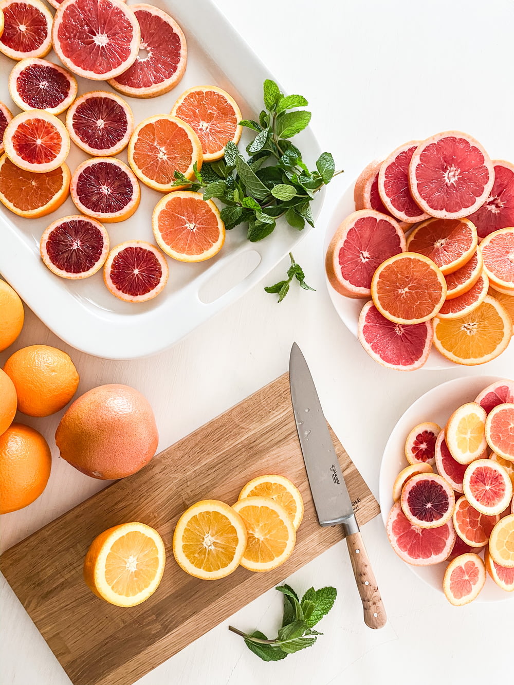a cutting board topped with sliced oranges next to a knife