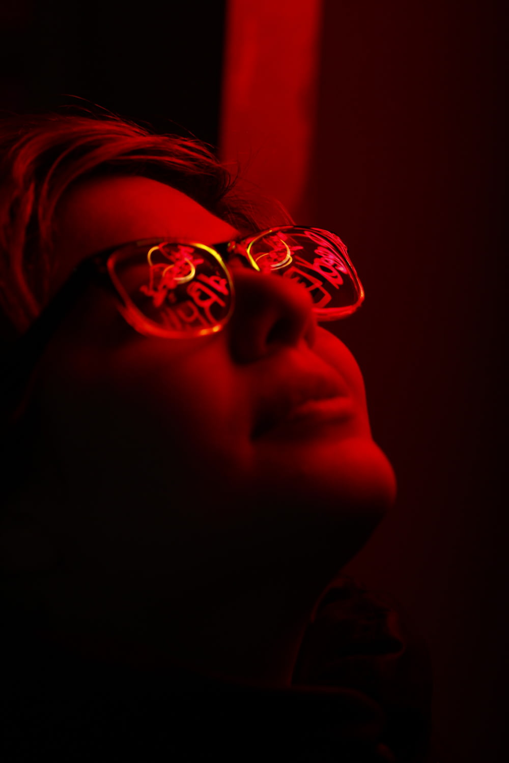 woman with eyeglasses in dim room