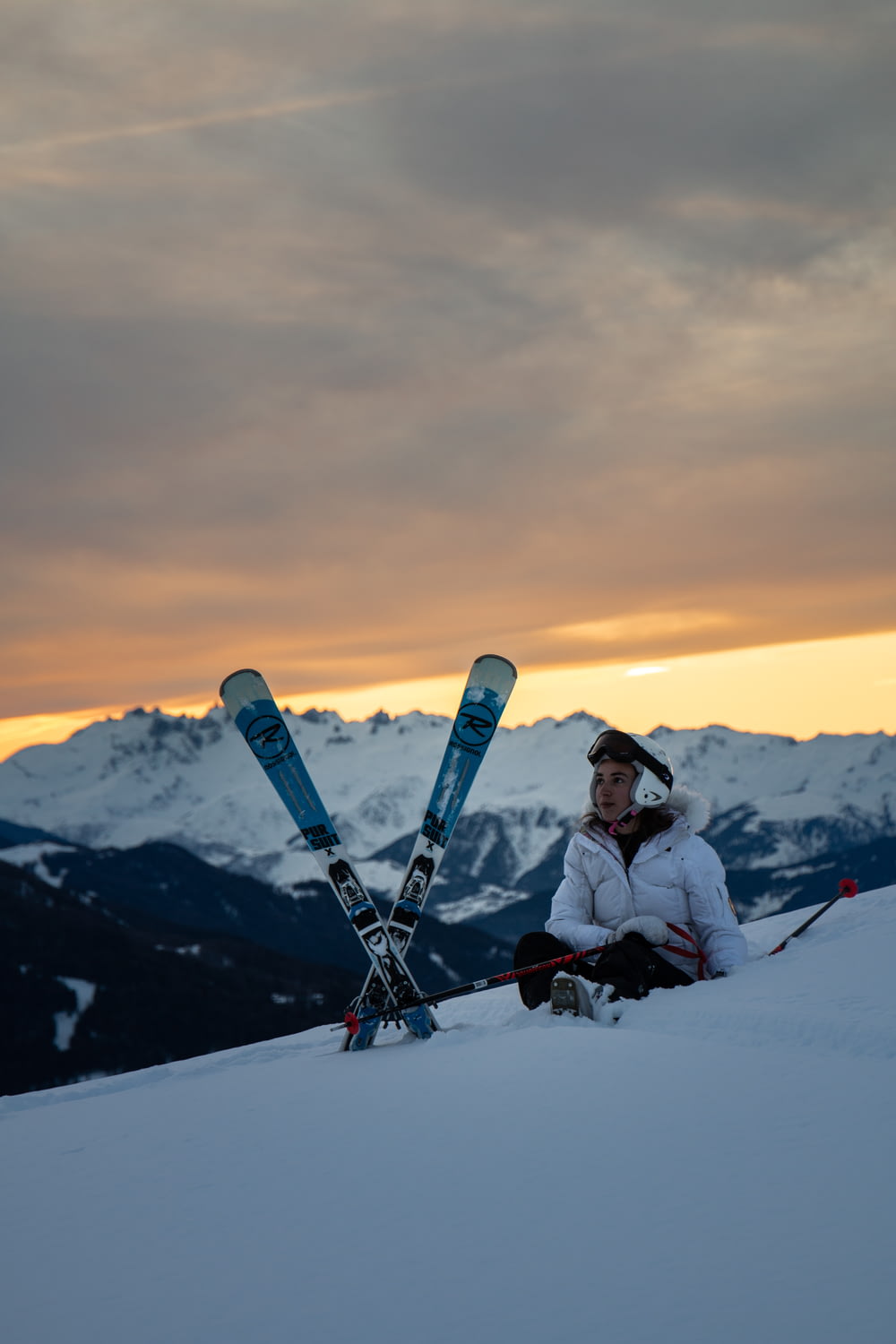 man sitting beside a snow ski blades