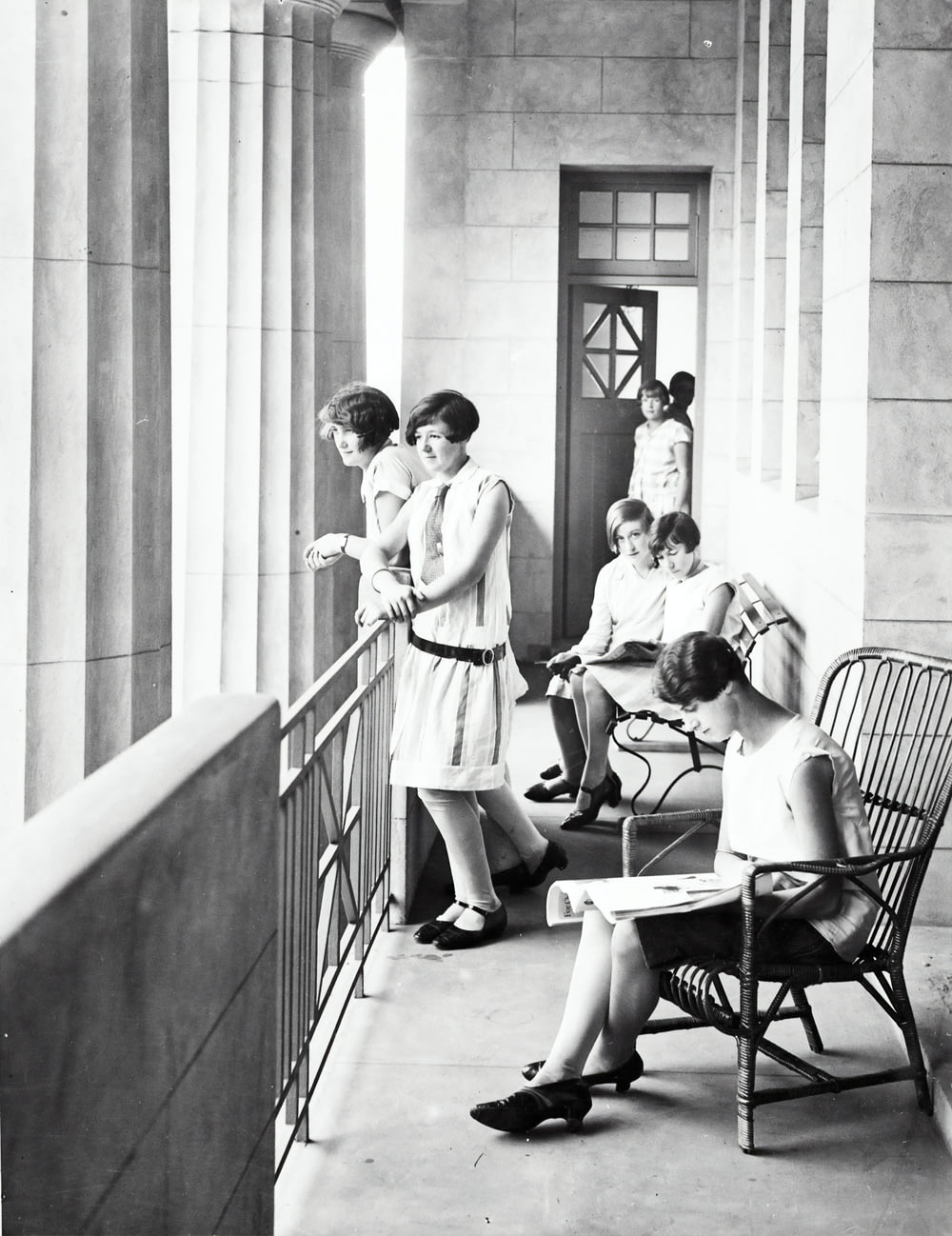 group of woman sitting and standing beside railing