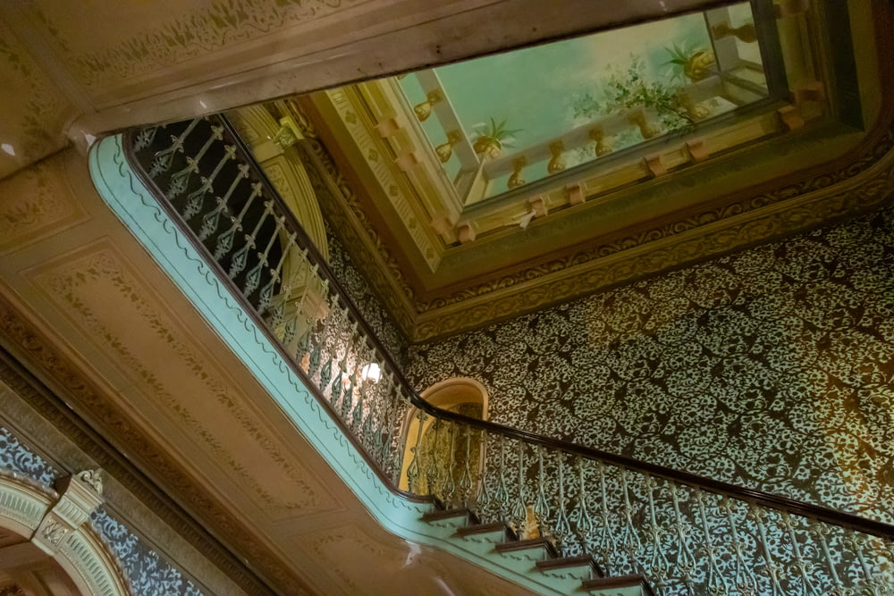 a stair case with a painting on the ceiling