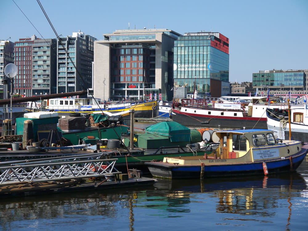 different boats on body of water near city with high-rise buildings during daytime
