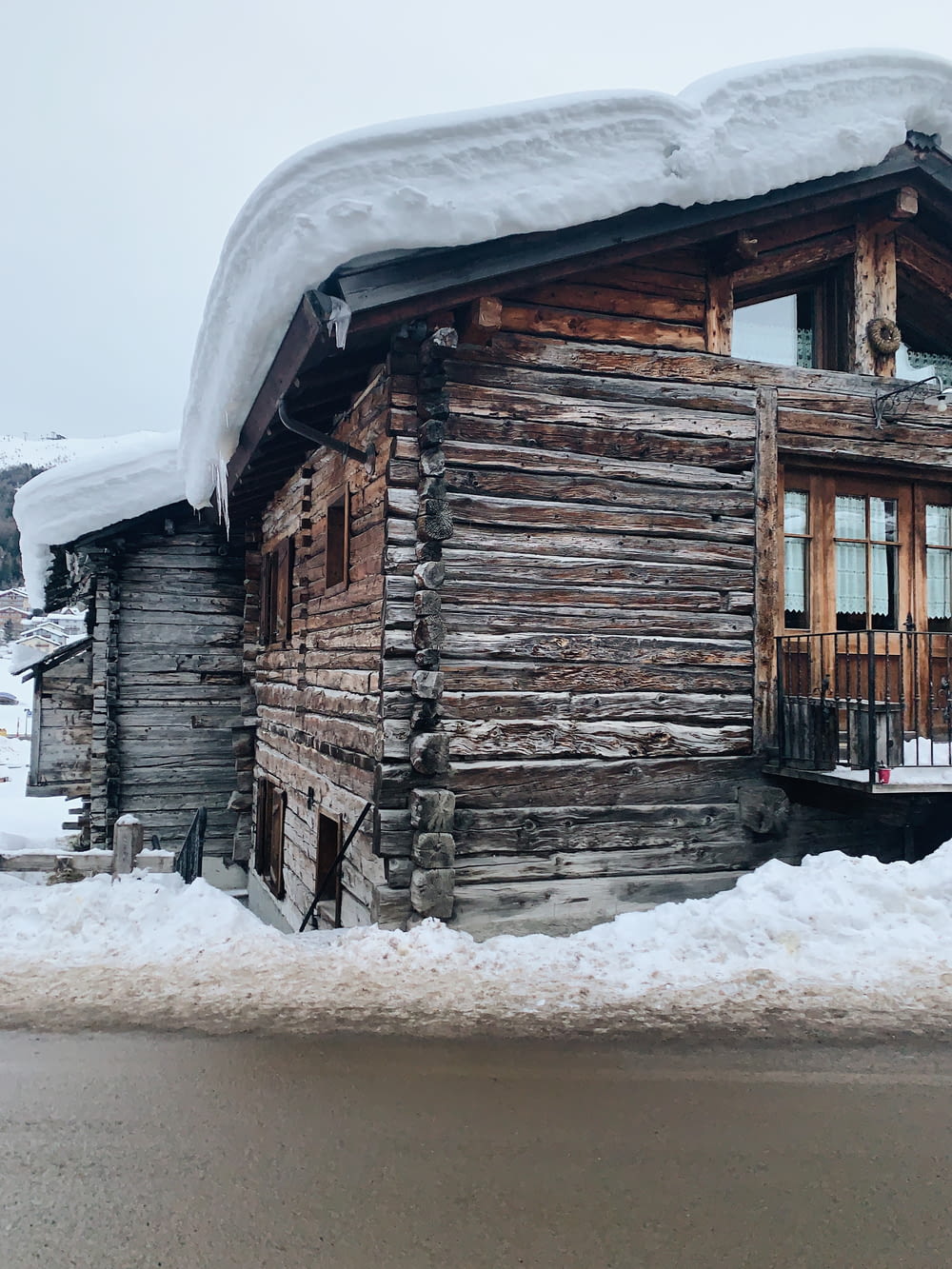 snow covered brown wooden house during daytime
