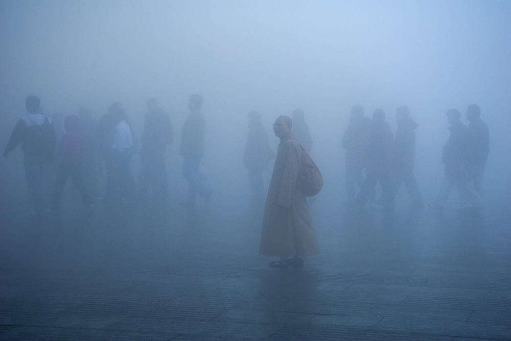 a group of people standing in a foggy area