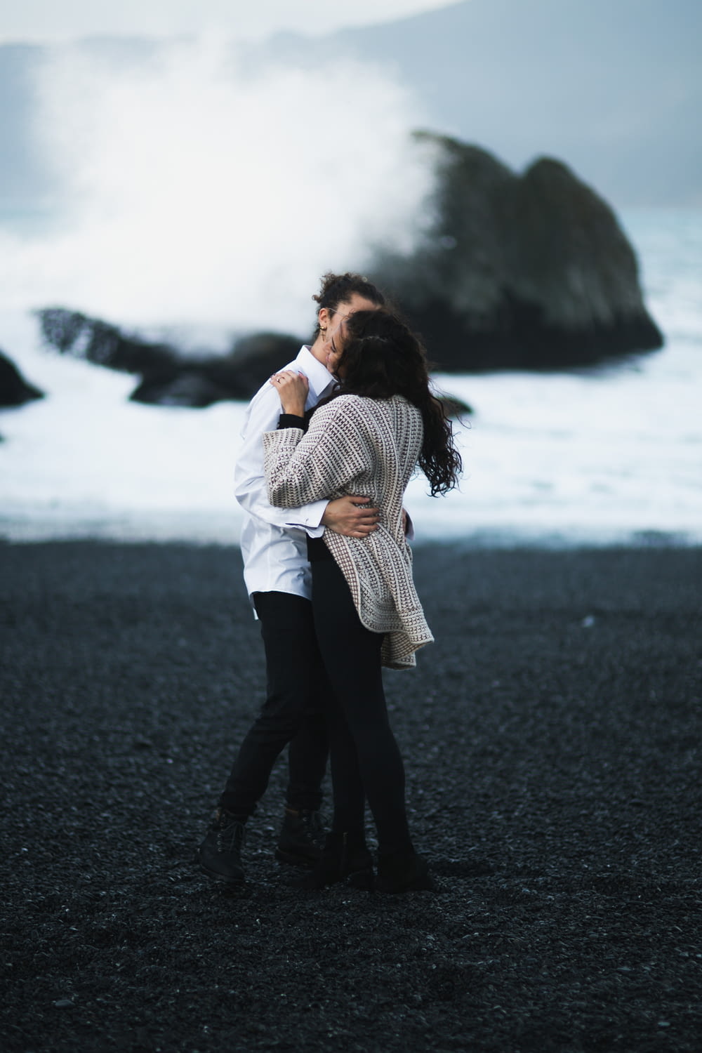 couple kissing on seashore during daytime