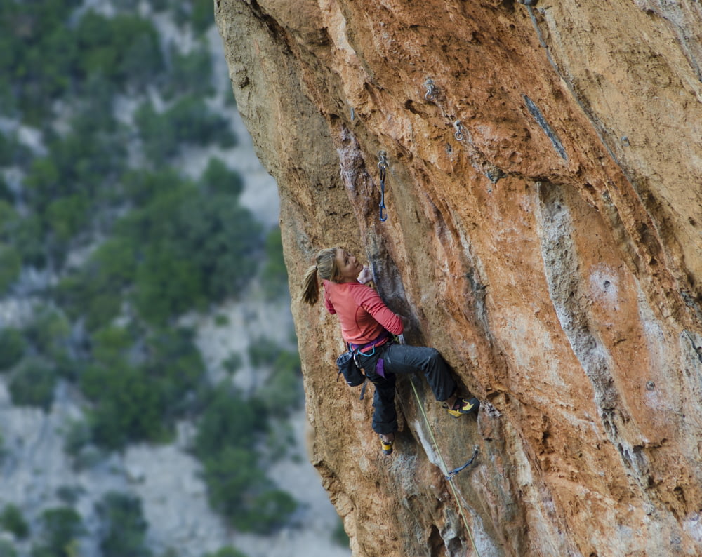 woman climbing on rock cliff